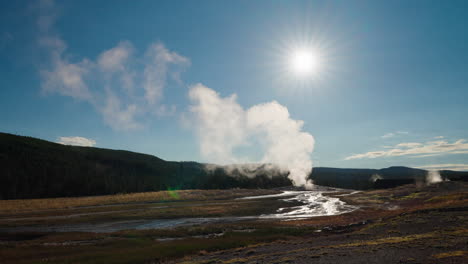 steaming geothermal landscape with river and sun