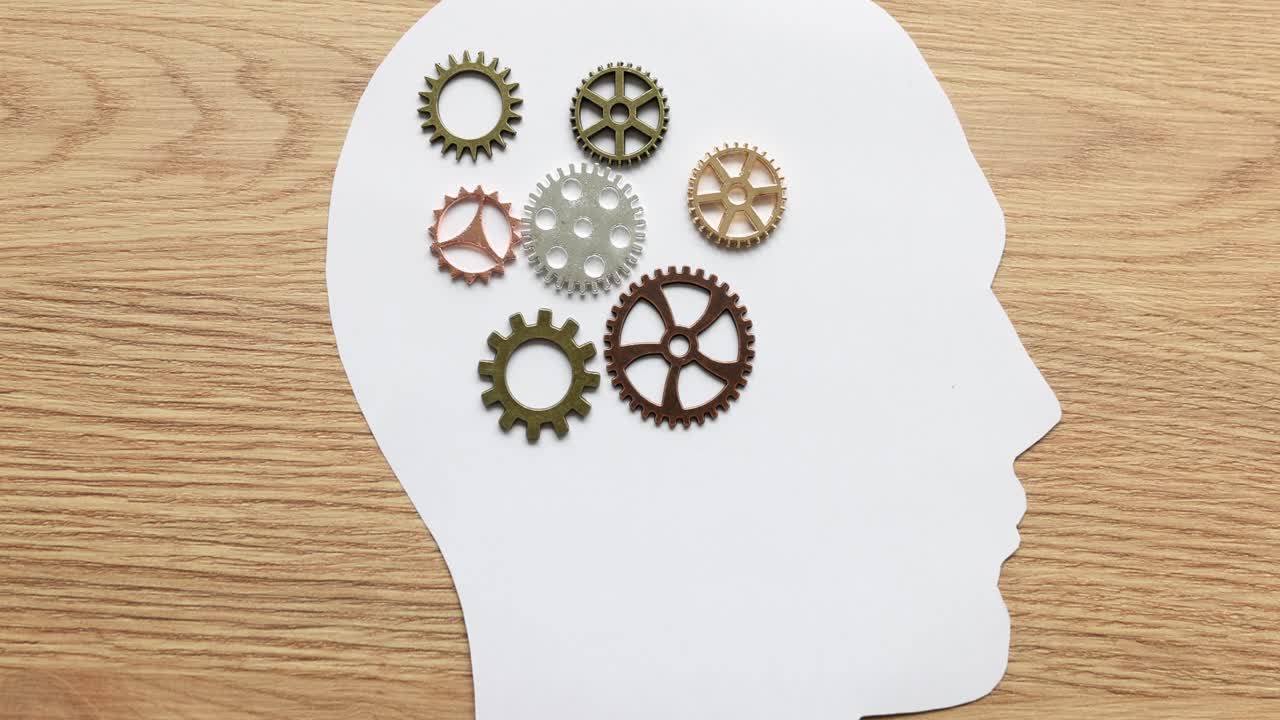 Gears in a human head silhouette representing thought and mind