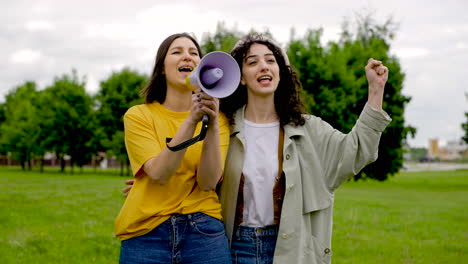 deux amies dans une manifestation à l'aide d'un mégaphone