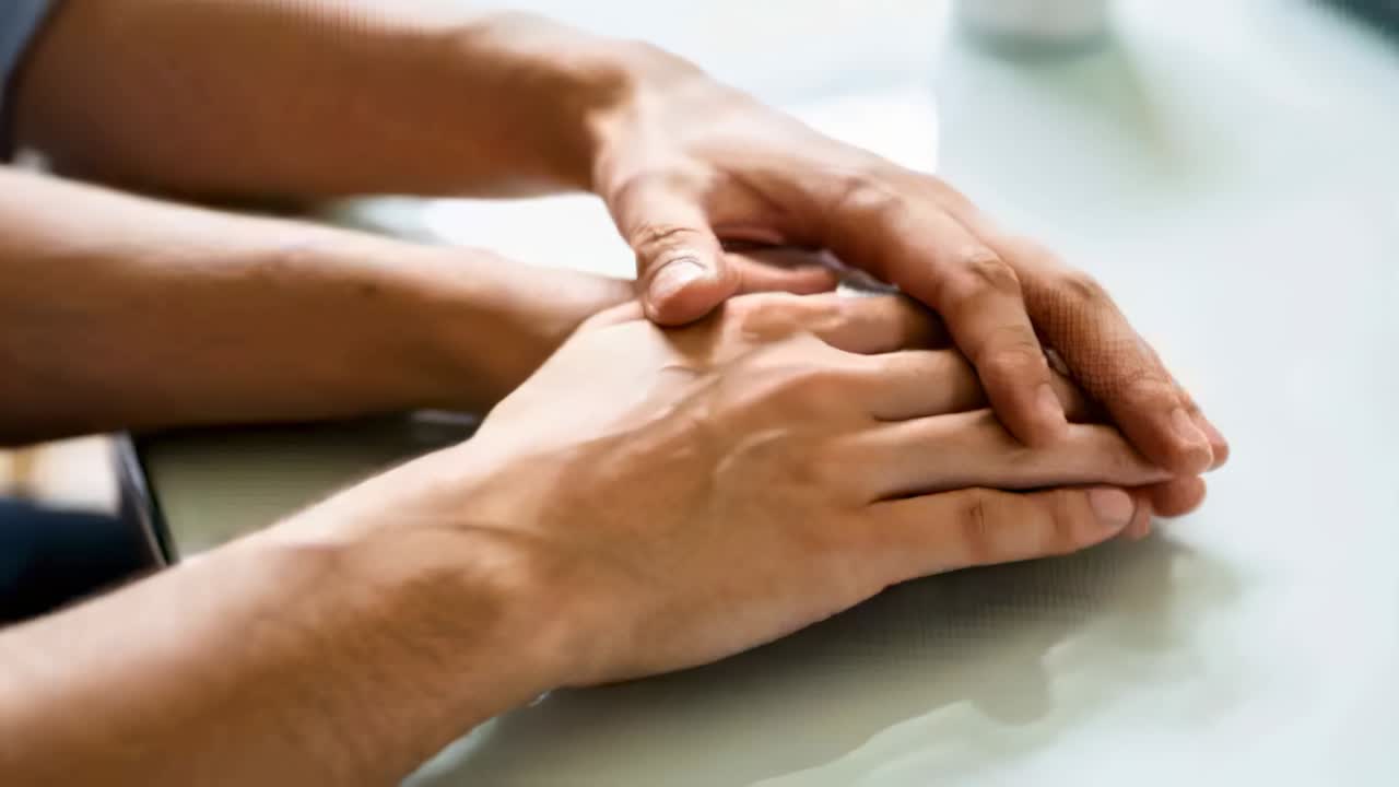 Manos adultas moviéndose, frotándose y entrelazándose sobre una mesa brillante después de una breve pausa para reconfortarse con una taza.
