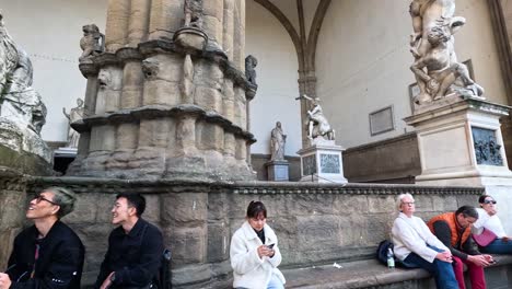 people sitting and interacting near statues