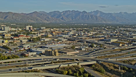 salt lake city, utah, toma panorámica v23 aérea que captura el cruce de tráfico en una carretera compleja con el paisaje urbano del centro y un hermoso paisaje montañoso - filmada con una cámara inspire 2, x7 - octubre de 2021