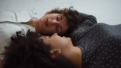 una pareja feliz hablando en la cama.