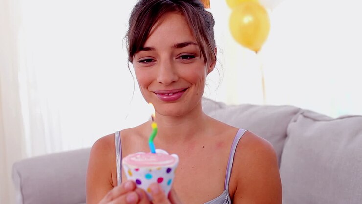 Brithday girl blowing out the candle on cupcake