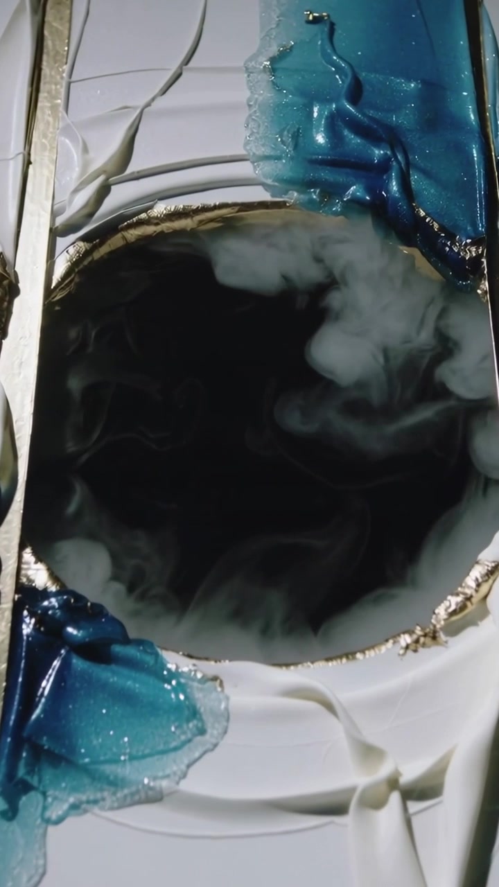 Vertical video: Focusing camera, panel showing mist swirling in black well, studio with blue resin