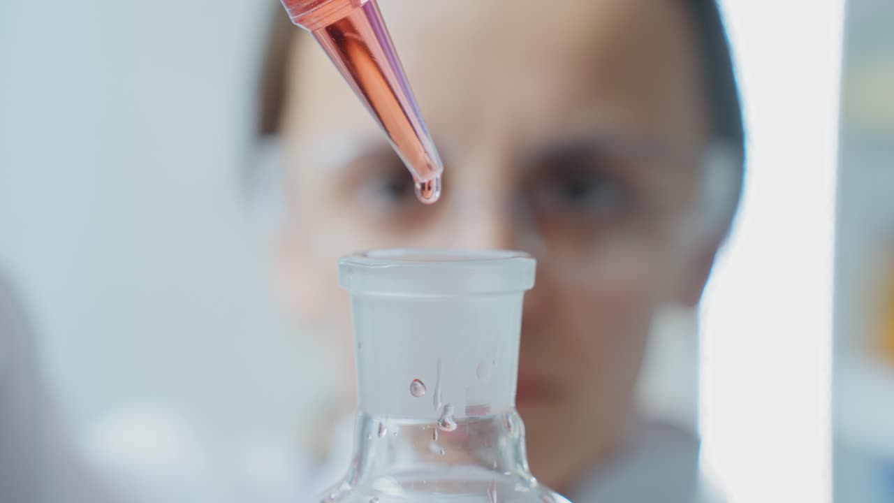 Scientist transferring liquid to flask