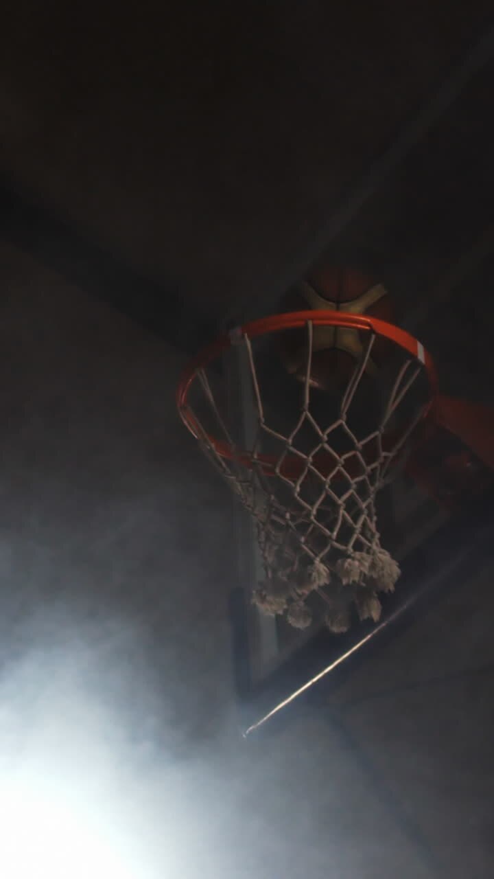 deportista sumergiendo baloncesto en el aro