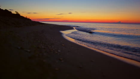 Panorama-view-peaceful-seashore-with-mountain-silhouette-at-golden-sunrise