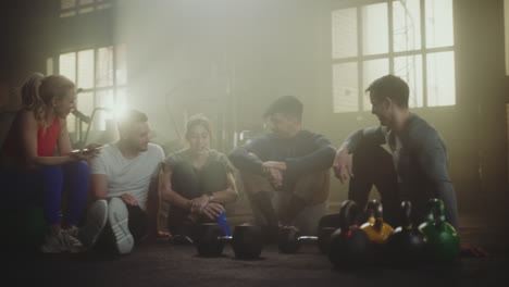 friends relaxing and talking in gym