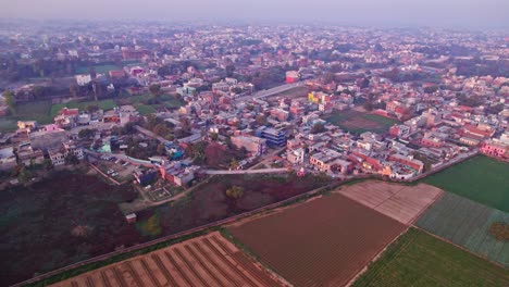 crop field lands with city view and sky at ayodhya, uttar pradesh, india. day time, push in, drone shot, 4k.