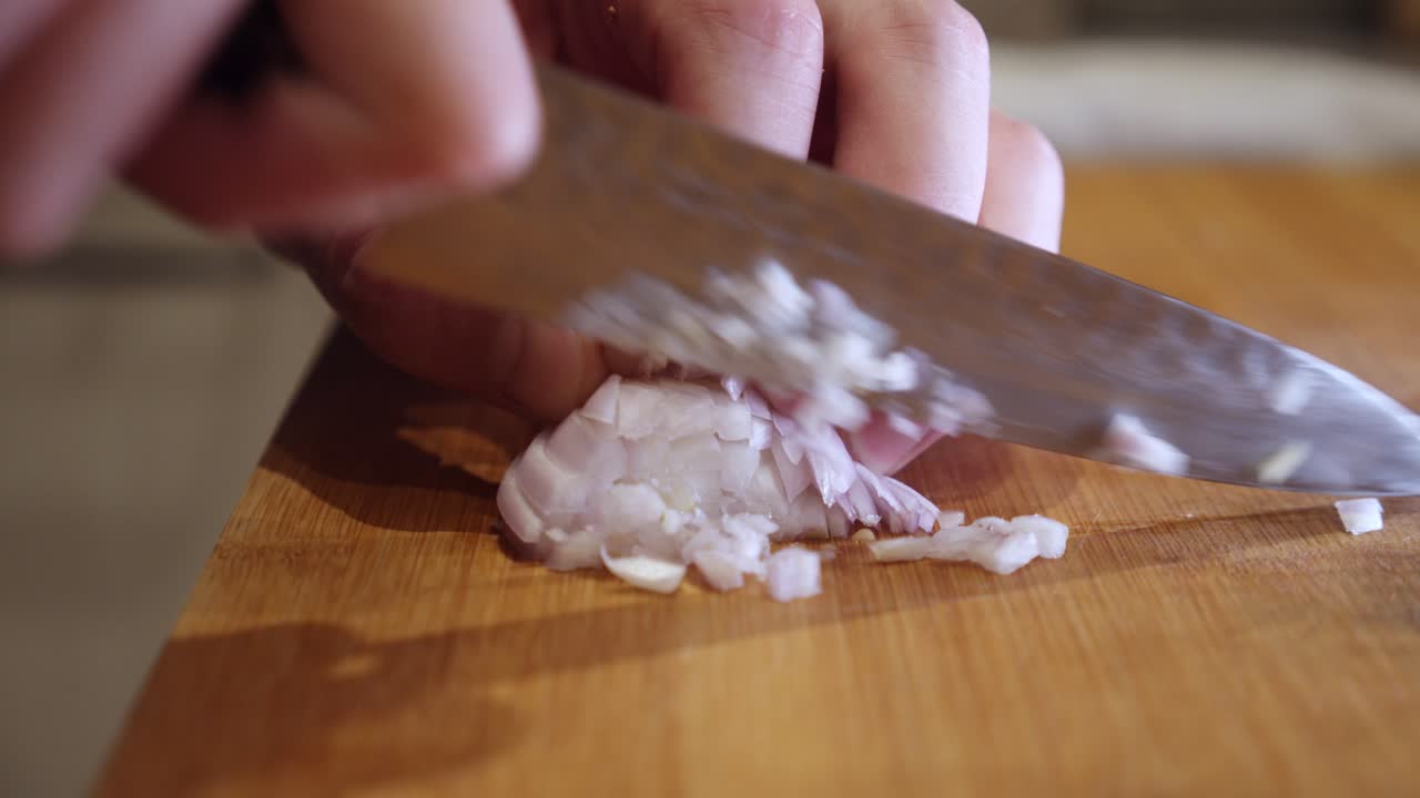 Chopping onion with sharp knife on a cut board