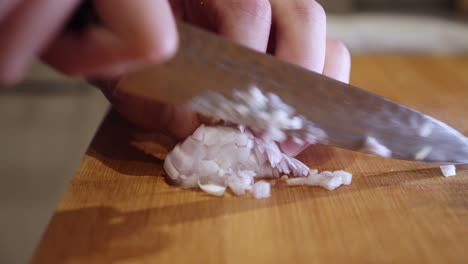 picar cebolla con un cuchillo afilado en una tabla cortada