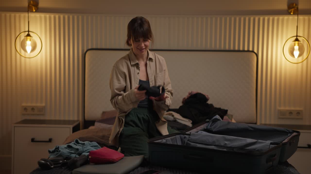 mujer empacando una maleta en el dormitorio