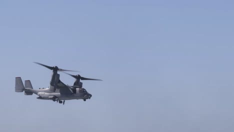 a tiltrotor aircraft smoothly transitions through the air, showcasing its unique rotor configuration against a clear blue sky.