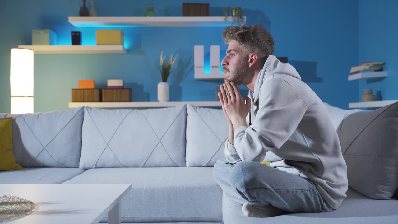 Sad Young Man Covering His Face With His Hands At Home.