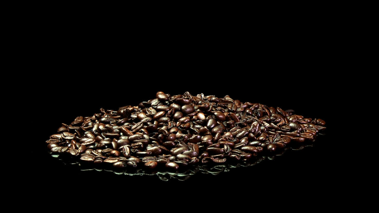 천천히 회전하는 볶은 커피 콩 더미의 먼 샷