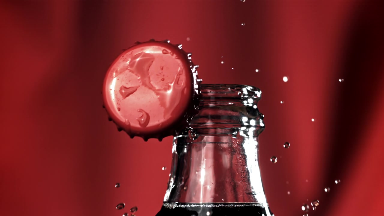 Tappo di Bottiglia Rosso che Salta Via da una Bevanda al Rallentatore