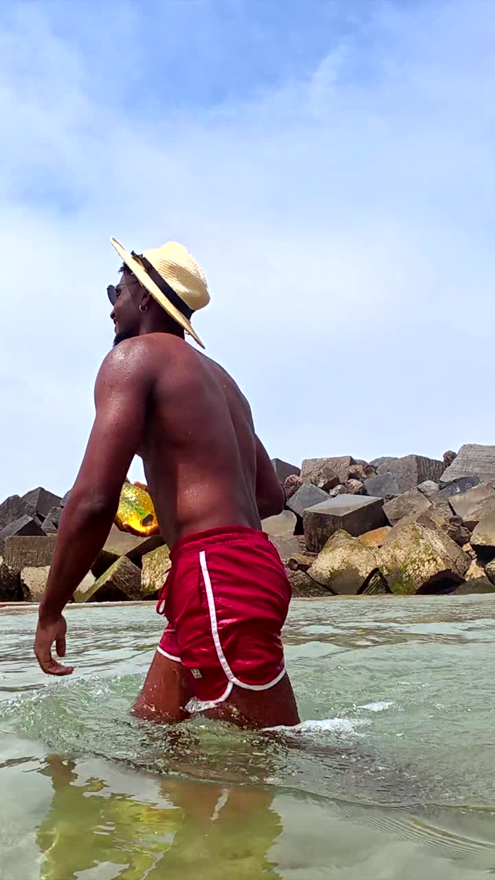 Uomo che si gode la spiaggia con un drink all'ananas