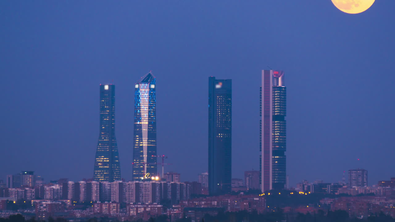 luna saliendo sobre las cuatro torres en madrid, españa