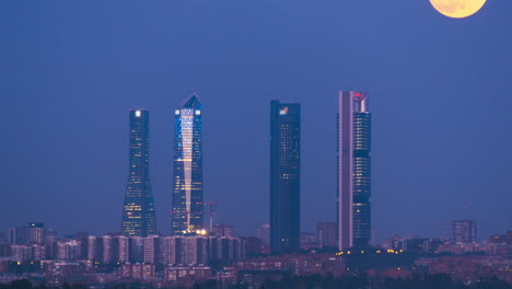 Moon-rising-over-the-Cuatro-Torres-in-Madrid,-Spain