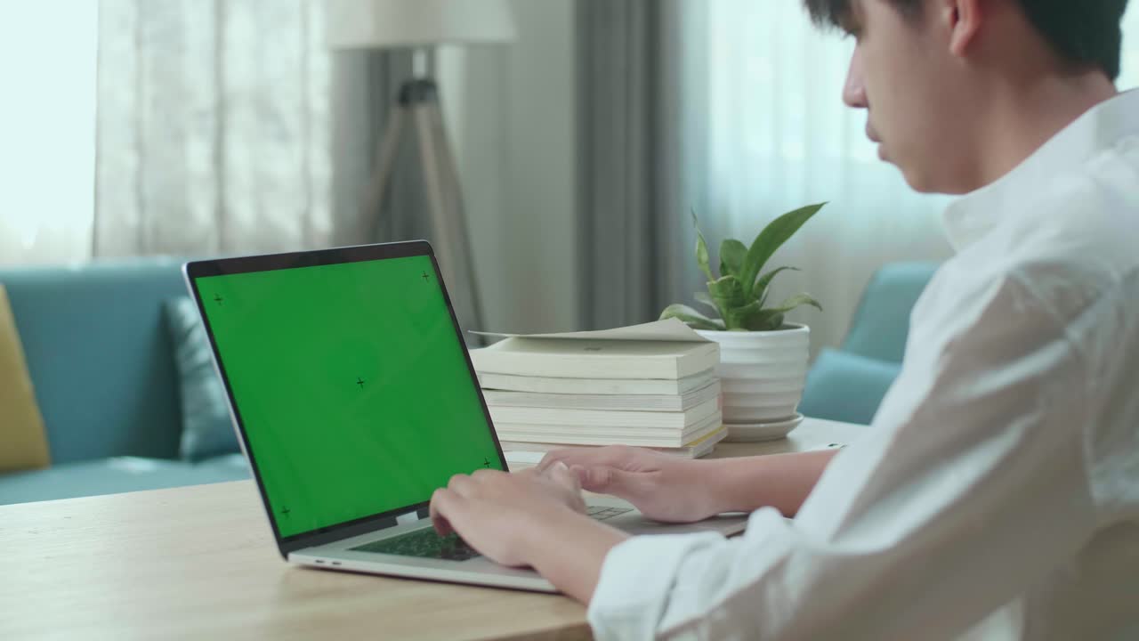 Close Up Of Asian Man Student Typing On Green Screen Computer At Home