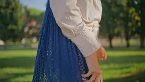 relaxed woman carrying sustainable bag strolling sunny nature park closeup.