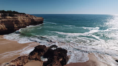 waves crashing onto rocks at the alba resort in algarve,portugal