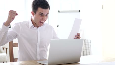 excited businessman celebrating results during paperwork at work