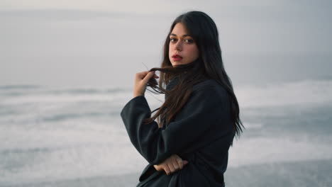 Woman-looking-night-ocean-close-up.-Brunette-standing-near-dramatic-ocean-view.