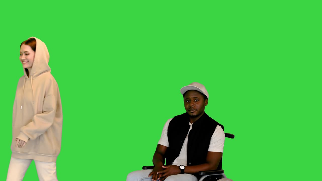 Afro-americano com deficiência em cadeira de rodas esperando por sua namorada caucasiana em uma tela verde, Chroma Key