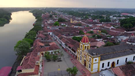as the town's historic charm unfolds below, the majestic church of maría inmaculada comes into view, its elegant facade standing as a testament to time. beyond. the vast magdalena river