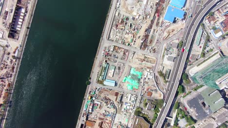 Mega-Construction-project-of-a-Housing-and-business-district-at-Kai-Tak-downtown-Hong-Kong,-with-vast-infrastructure-development-land-and-an-underwater-tunnel-laying-operation,-Aerial-view