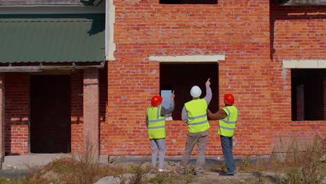 architect with senior civil engineers discussing project work with blueprint of building house