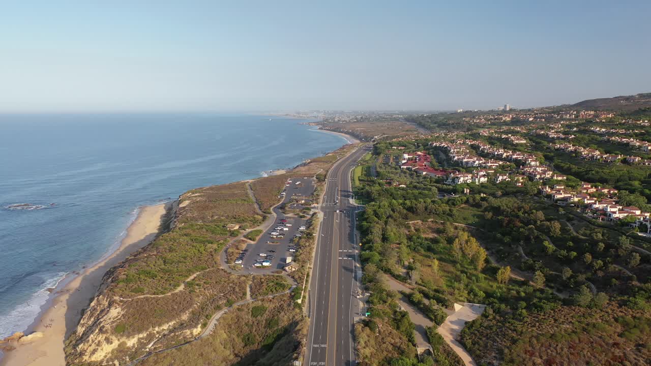 un dron aéreo se deslizó por la costa del condado de orange y reveló casas de lujo con vistas a las olas del océano en un día increíblemente soleado
