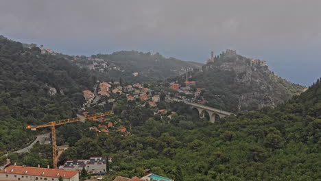Eze-France-Aerial-v17-cinematic-low-level-drone-flyover-hillside-neighborhood-toward-medieval-hilltop-village-and-old-church-of-our-lady-of-the-assumption---July-2021