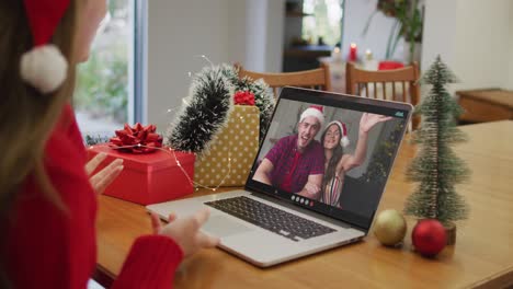 Happy-caucasian-woman-on-video-call-with-frienda-at-christmas-time