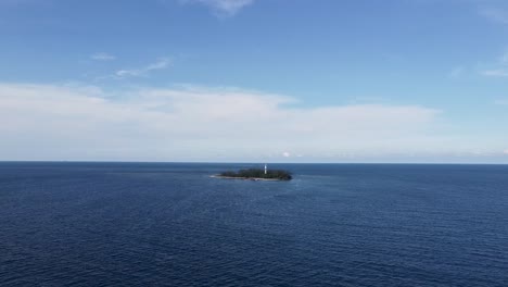 island with trees and white lighthouse surrounded by gulf of mexico