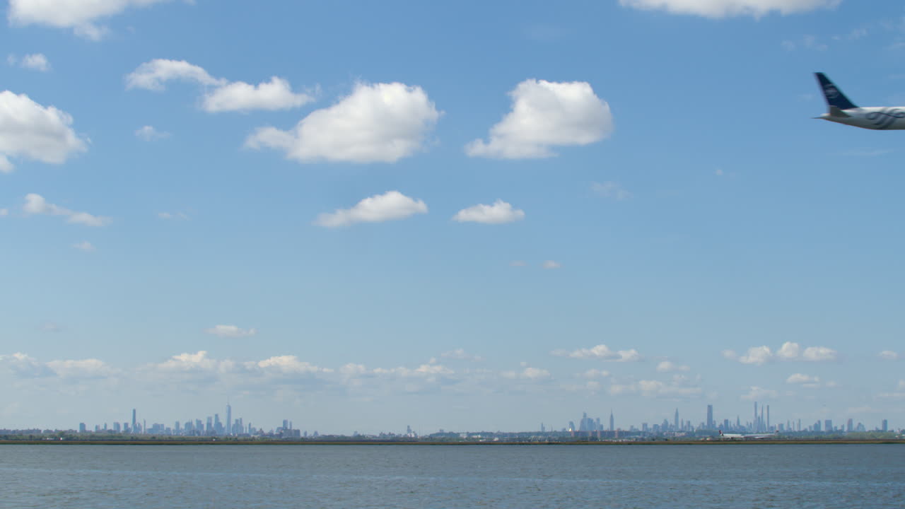 New York City Skyline on Clear Day with Passenger Jet Crossing Overhead on Approach to Landing at JFK Airport