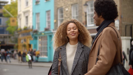 Stylish-Young-Couple-Talking-On-City-Street