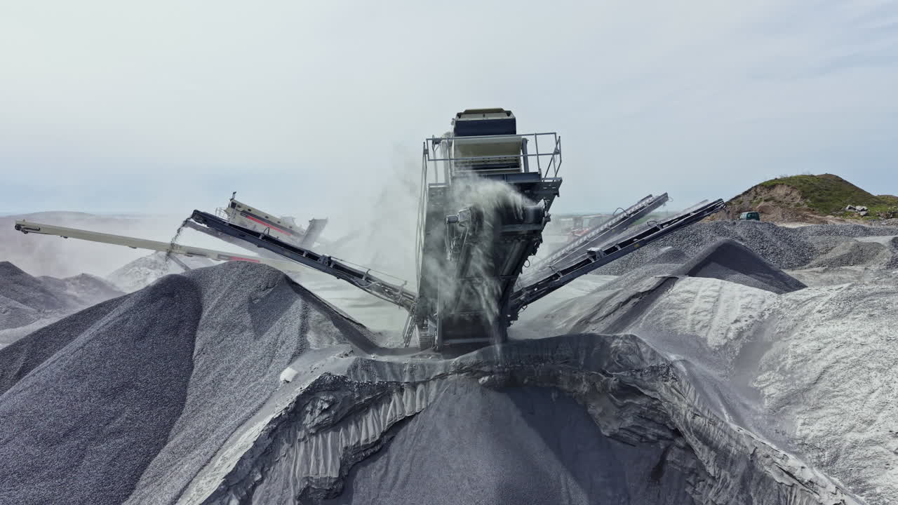 Granite quarry workers use heavy equipment to process stone at a mining site during the daytime