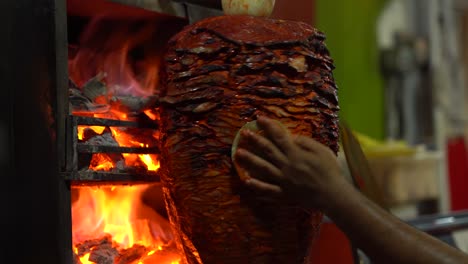 vendor slicing pork meat off a vertical spit al pastor in mexico, sayulita