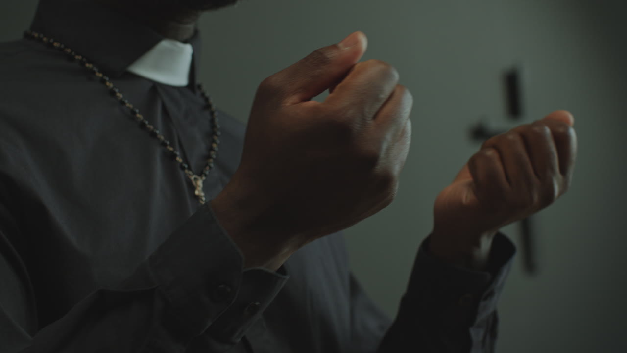 Mani di un sacerdote cattolico nero che parla durante un servizio liturgico in chiesa