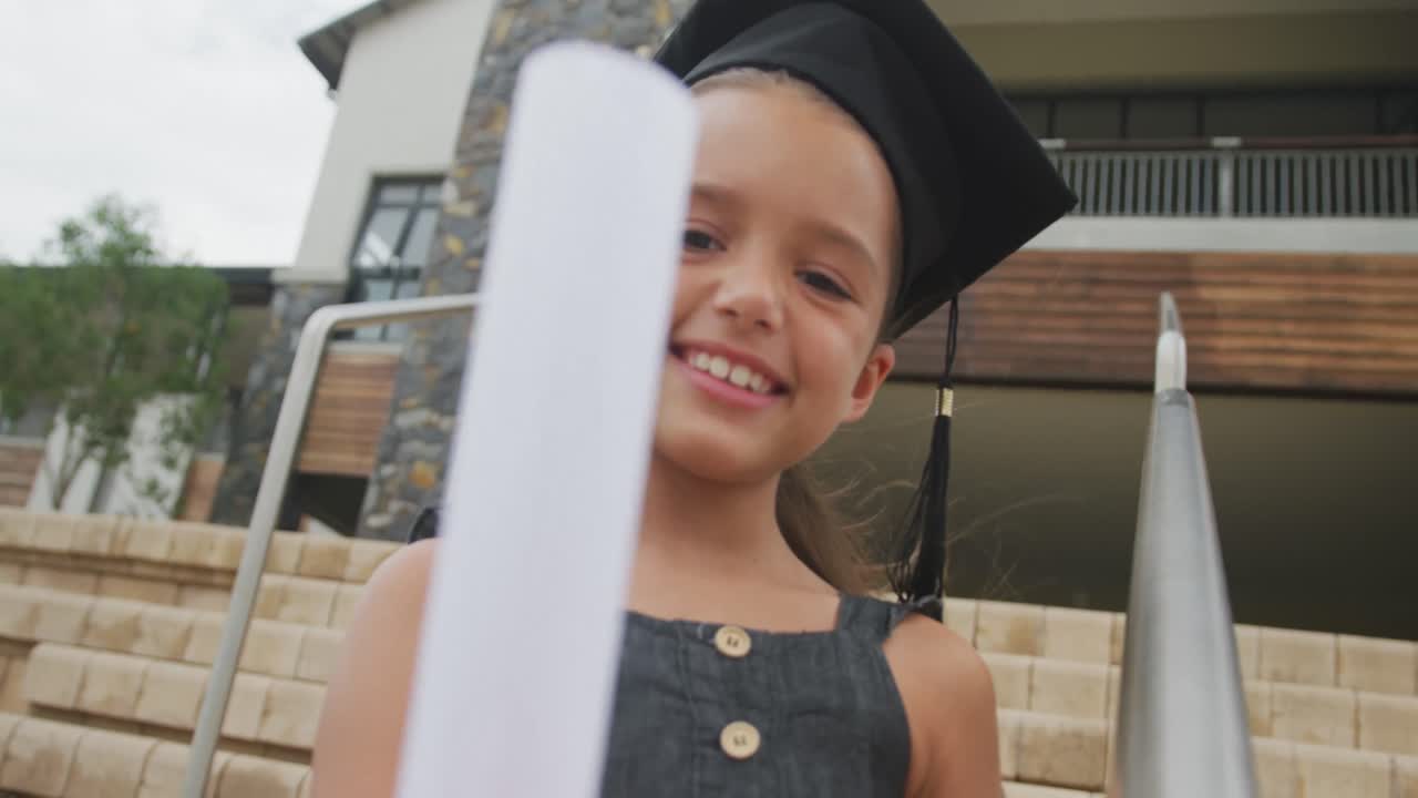 video de una chica caucásica feliz con un sombrero de graduación y un diploma en la mano
