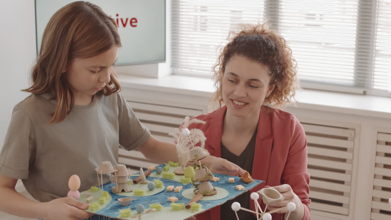 Girl and Teacher Discussing Craft Project