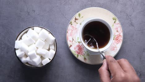 adding sugar to coffee or tea