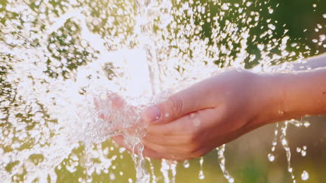 a stream of clear water falls in the palm of your hand slow motion video