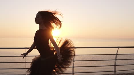 a ballerina practicing a ballet dance near the sea. preparing and doing a jump. wondeful sunlight on the backstage. slow motion