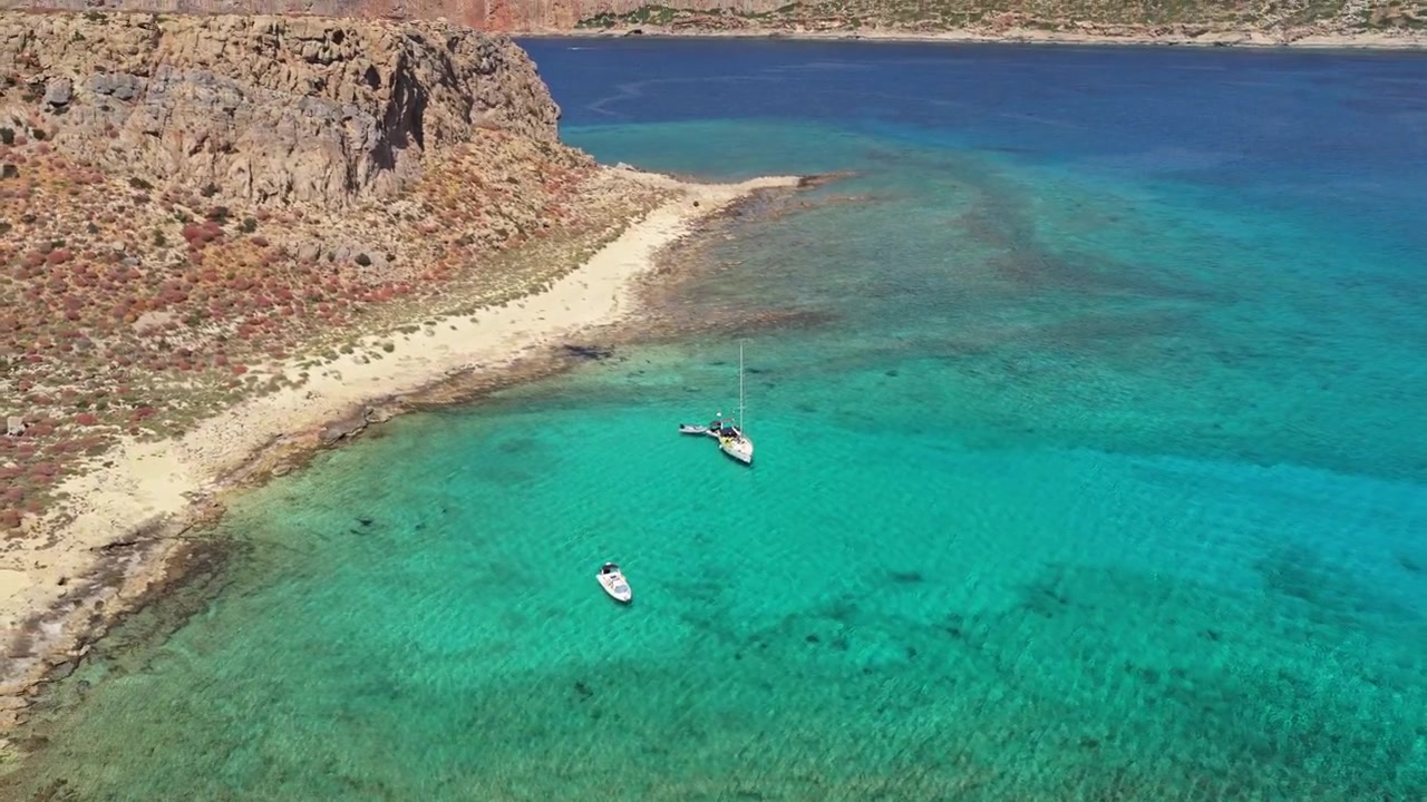 Vue aérienne par drone d'un voilier ancré dans des eaux turquoise cristallines près de la flèche de sable de l'île de Gramvousa, Gramvousa, Grèce
