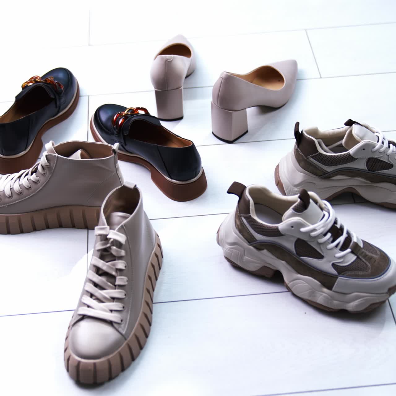 Diverse footwear put in circle on the white floor. Modern fashionable shoes for different occasions. Close up