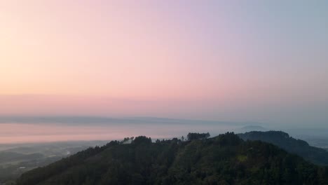 Aerial-Panorama-view-of-green-mountains-and-foggy-sky-during-mystic-colorful-sunrise-at-horizon